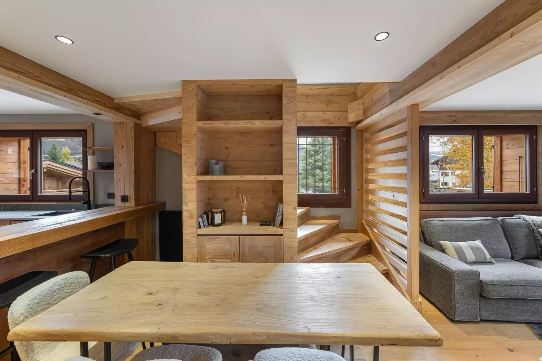 Una sala-comedor de madera de planta abierta con una mesa grande.