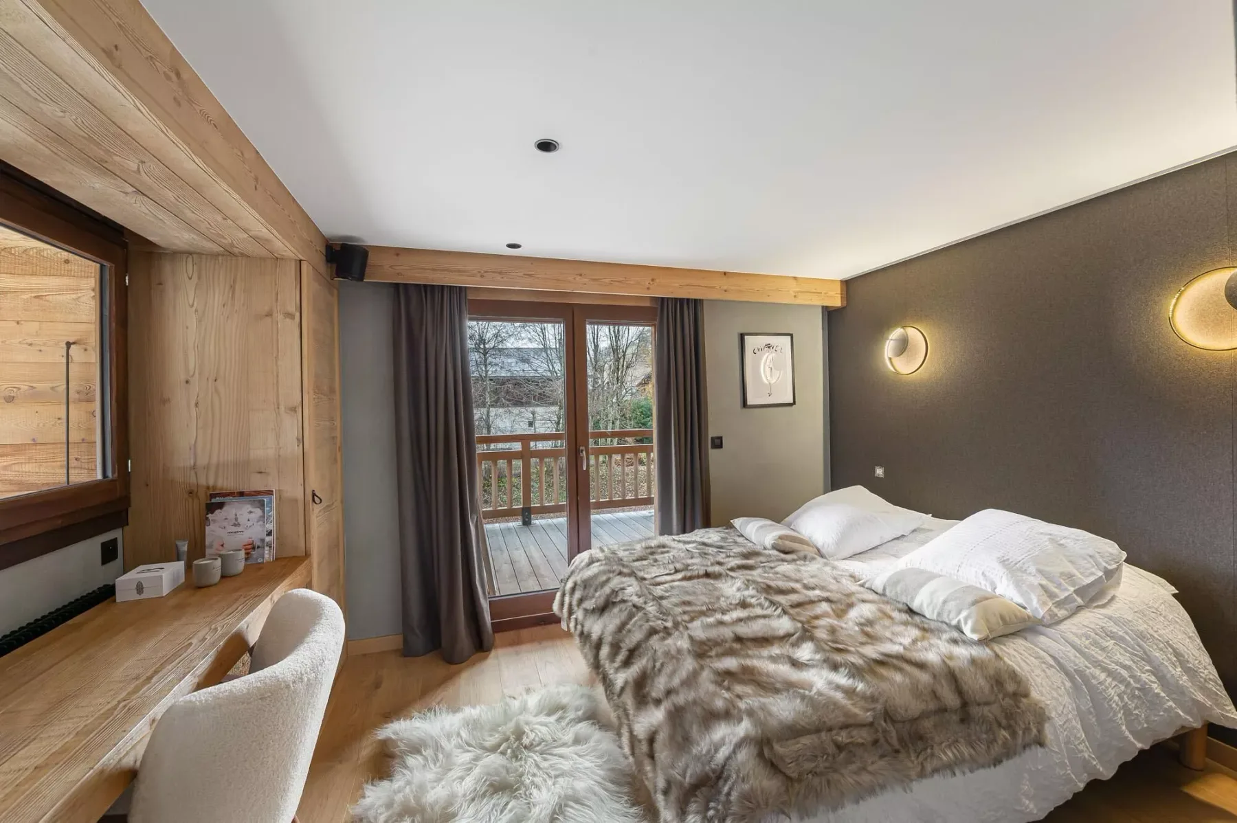 Dormitorio con una cama junto a una puerta de cristal que da a un balcón.