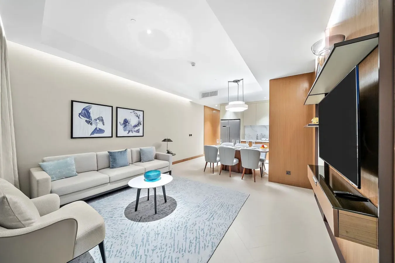 Una sala de estar moderna con asientos alrededor de una mesa de centro y un comedor abierto.