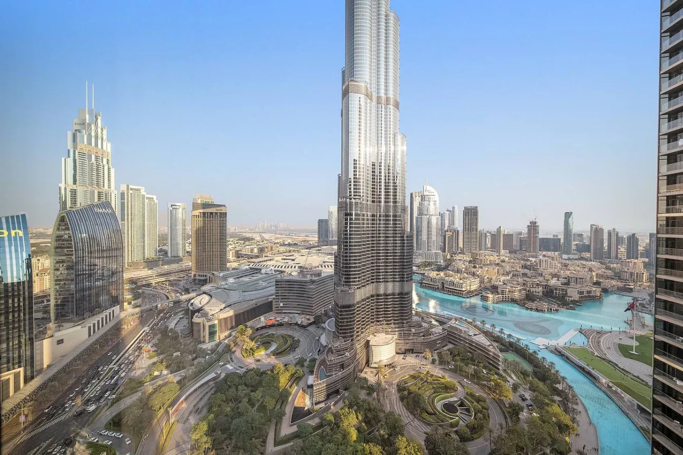 Un horizonte urbano con una torre muy alta en el centro y una zona de agua turquesa.