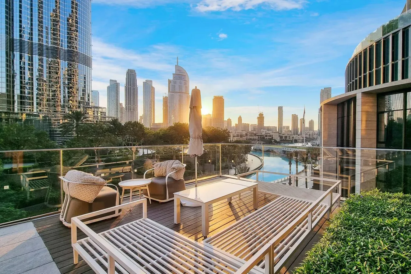 Una terraza en la azotea con asientos al aire libre da a un horizonte urbano y agua.