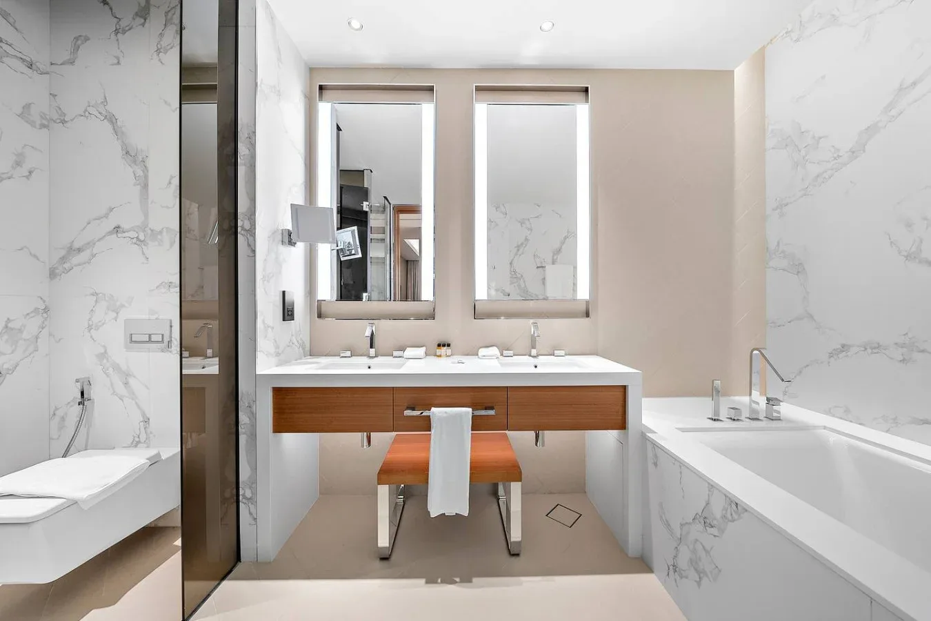 Un baño luminoso cuenta con un tocador de doble lavabo junto a una bañera.
