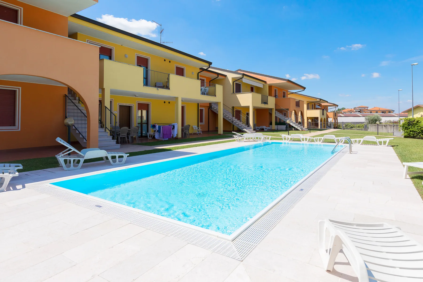 Una piscina al aire libre junto a una fila de edificios coloridos.