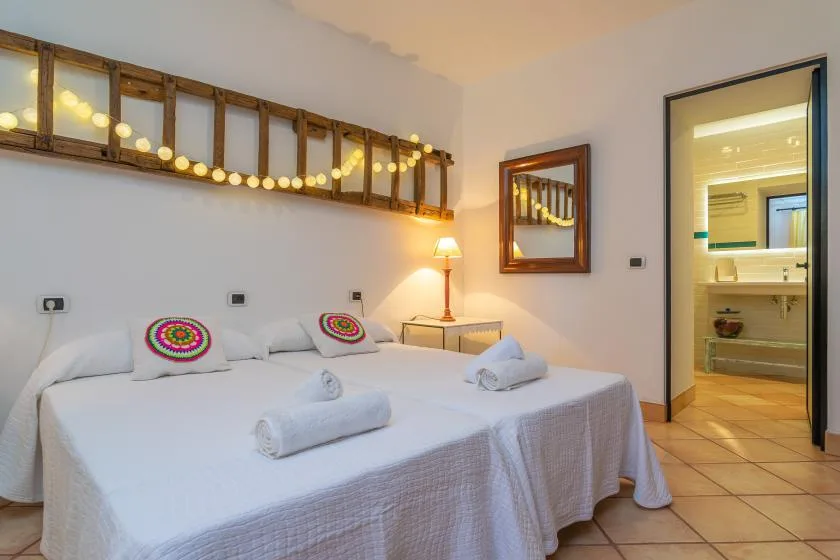A bedroom with two neatly made beds and a decorative wooden wall feature.