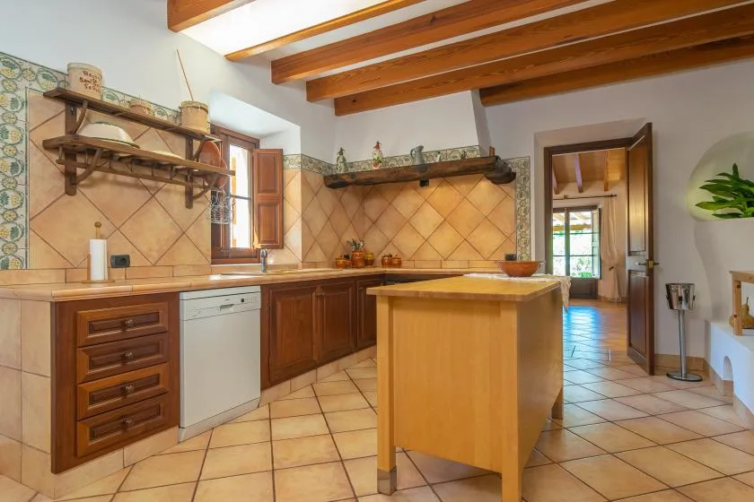 A kitchen with wooden cabinets, tiled walls, and a central island.