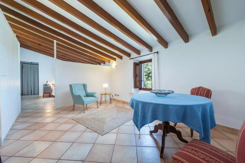 A dining area with a round table covered in blue cloth and a seating nook.