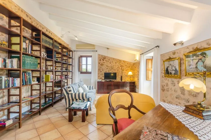 A living room with tall bookshelves, seating, and a television.