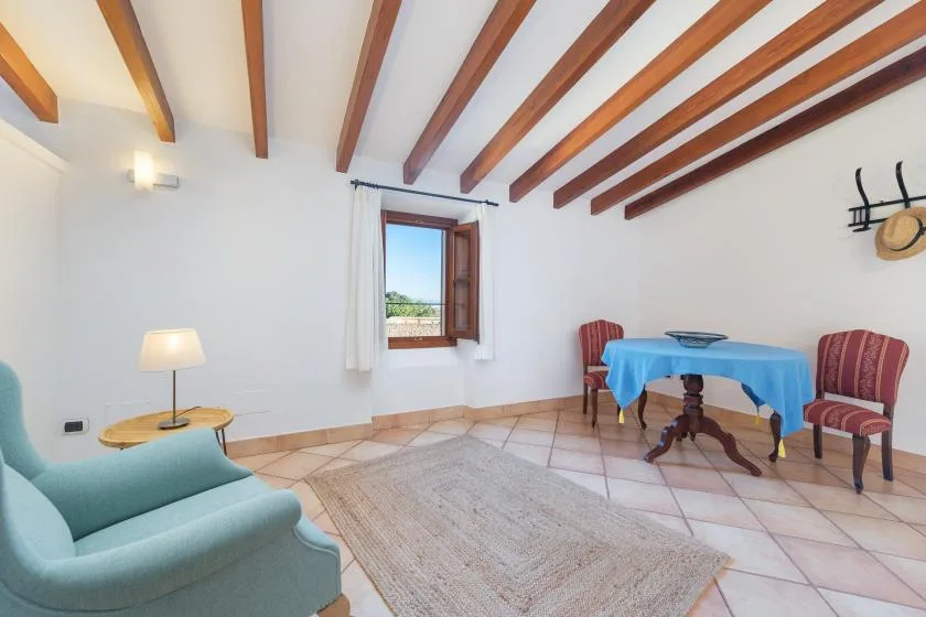 A sitting room with a small table and chairs beside a window.