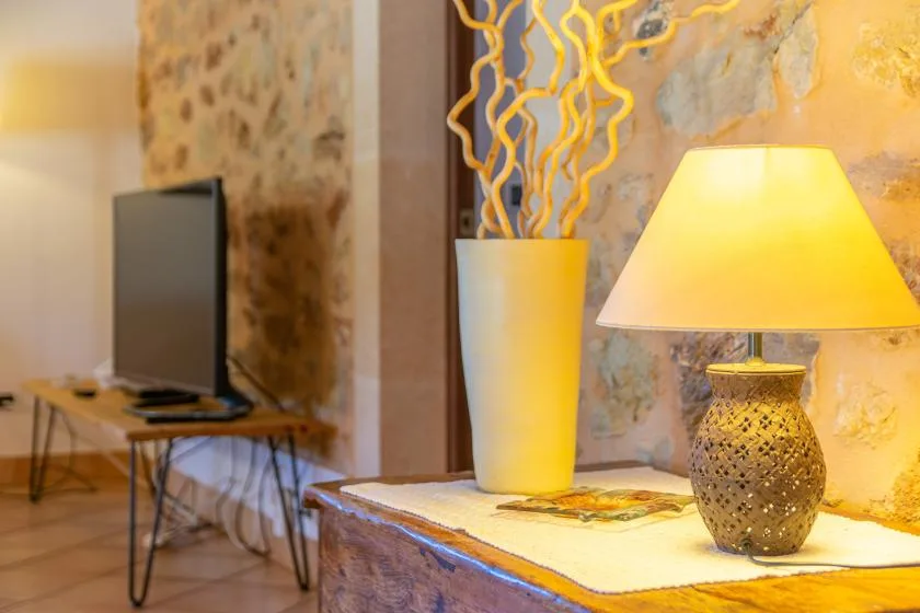 A warmly lit living room with a television and decorative lamps.