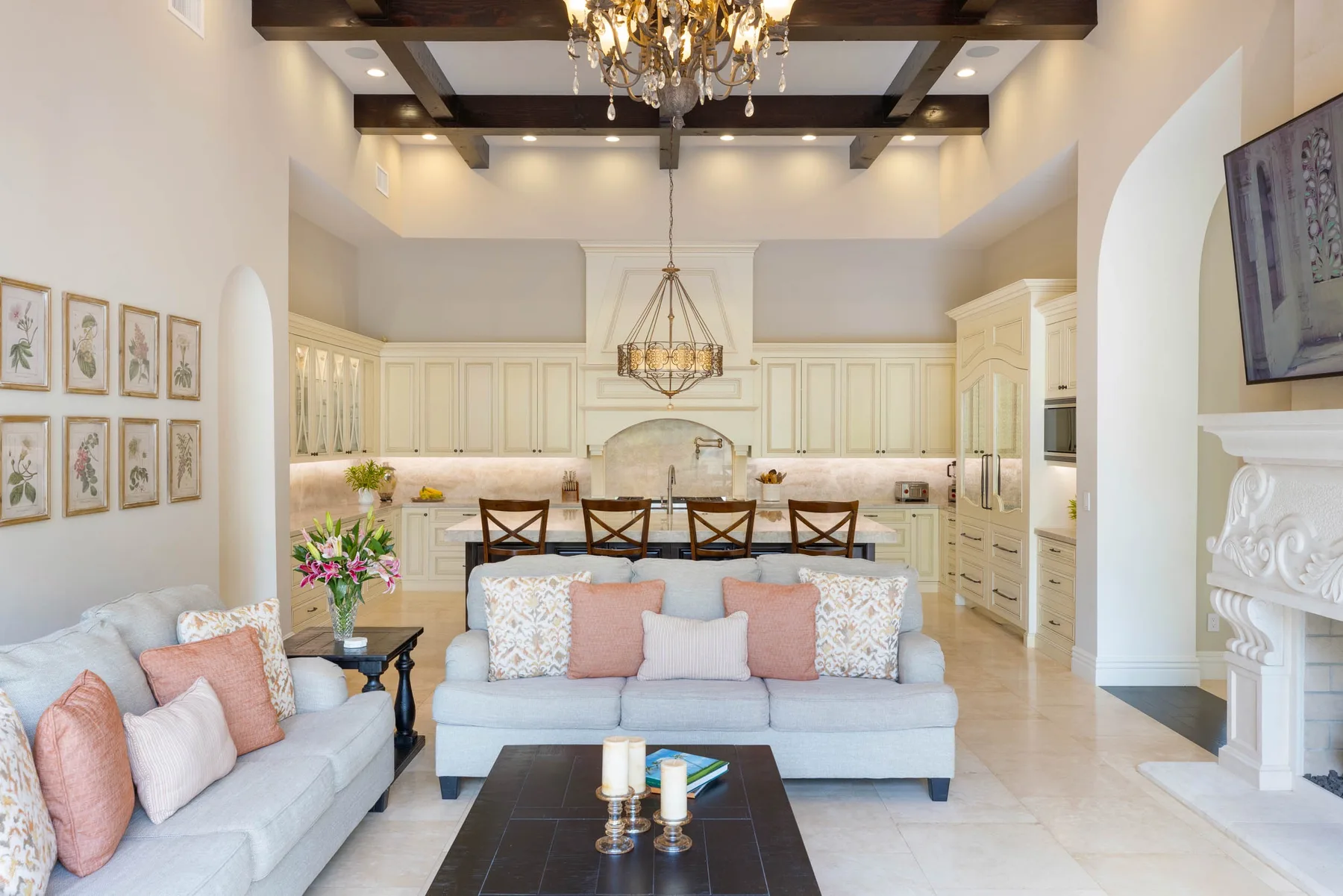 Una luminosa sala de estar y cocina de concepto abierto, con asientos claros y gabinetes blancos.