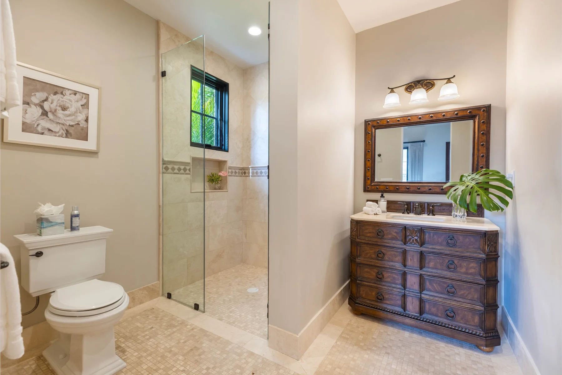 Un baño con ducha de vidrio, inodoro y tocador de madera.