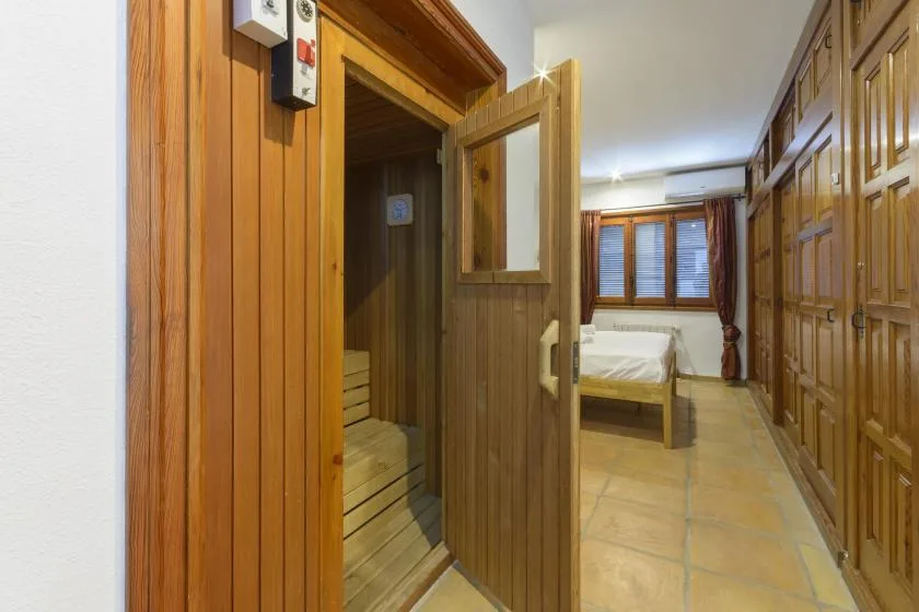 A bedroom with a wooden bed and a row of built-in cupboards.