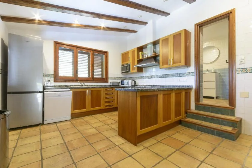 A kitchen with wooden cabinets, a central island, and a window above the counter.