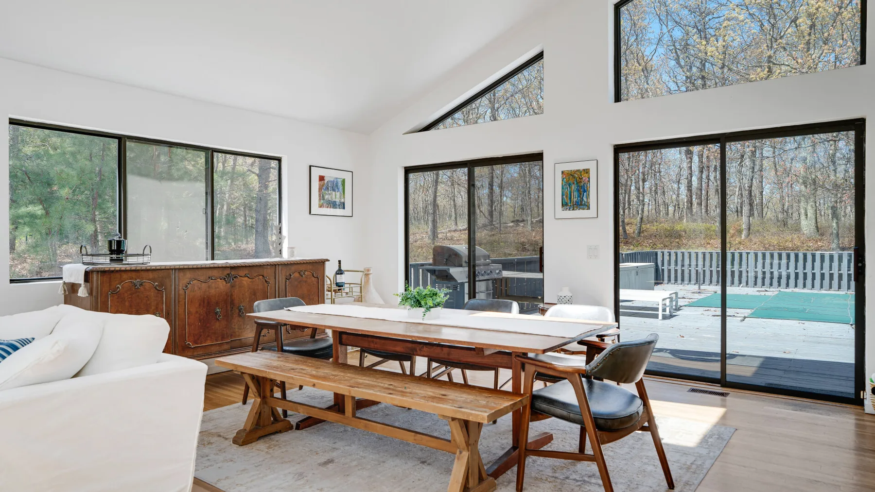 Un comedor luminoso con una larga mesa de madera junto a grandes ventanas.