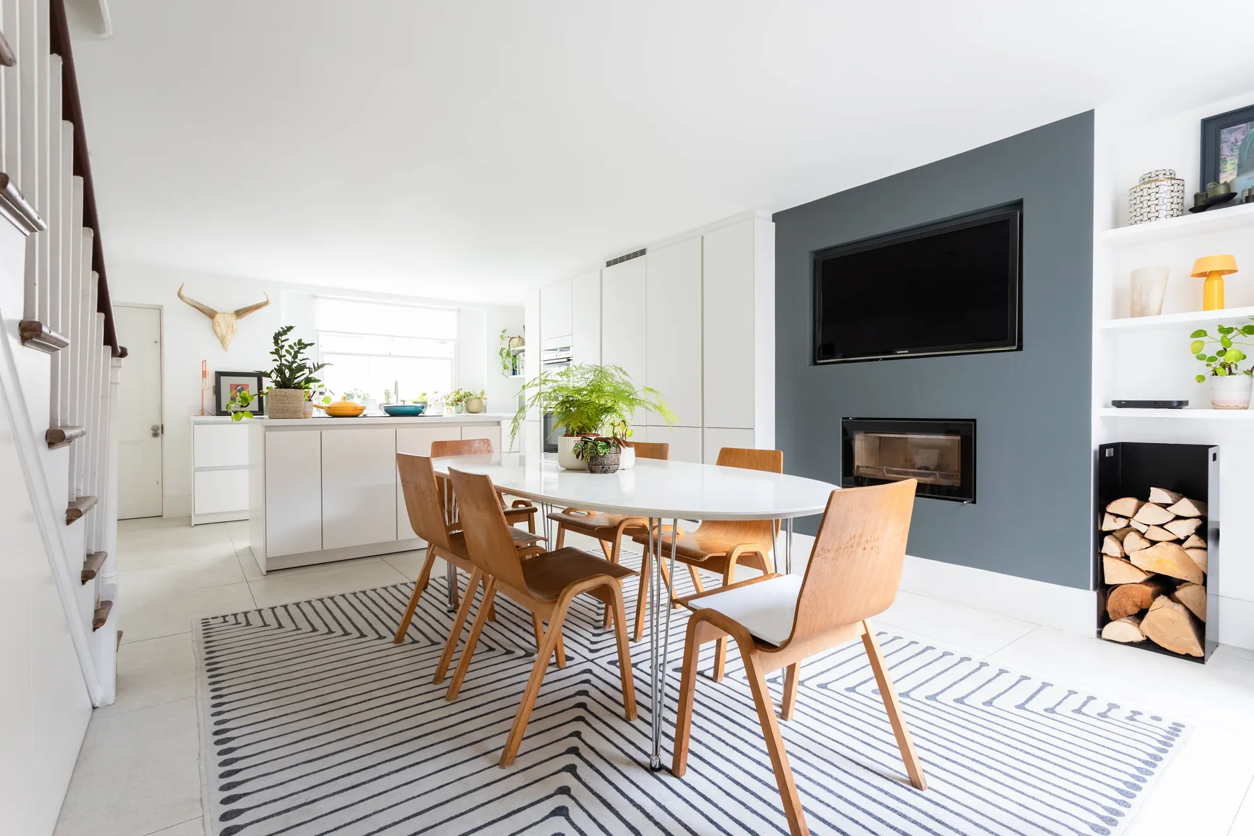 Un comedor luminoso y abierto, con mesa y sillas de madera junto a la cocina.