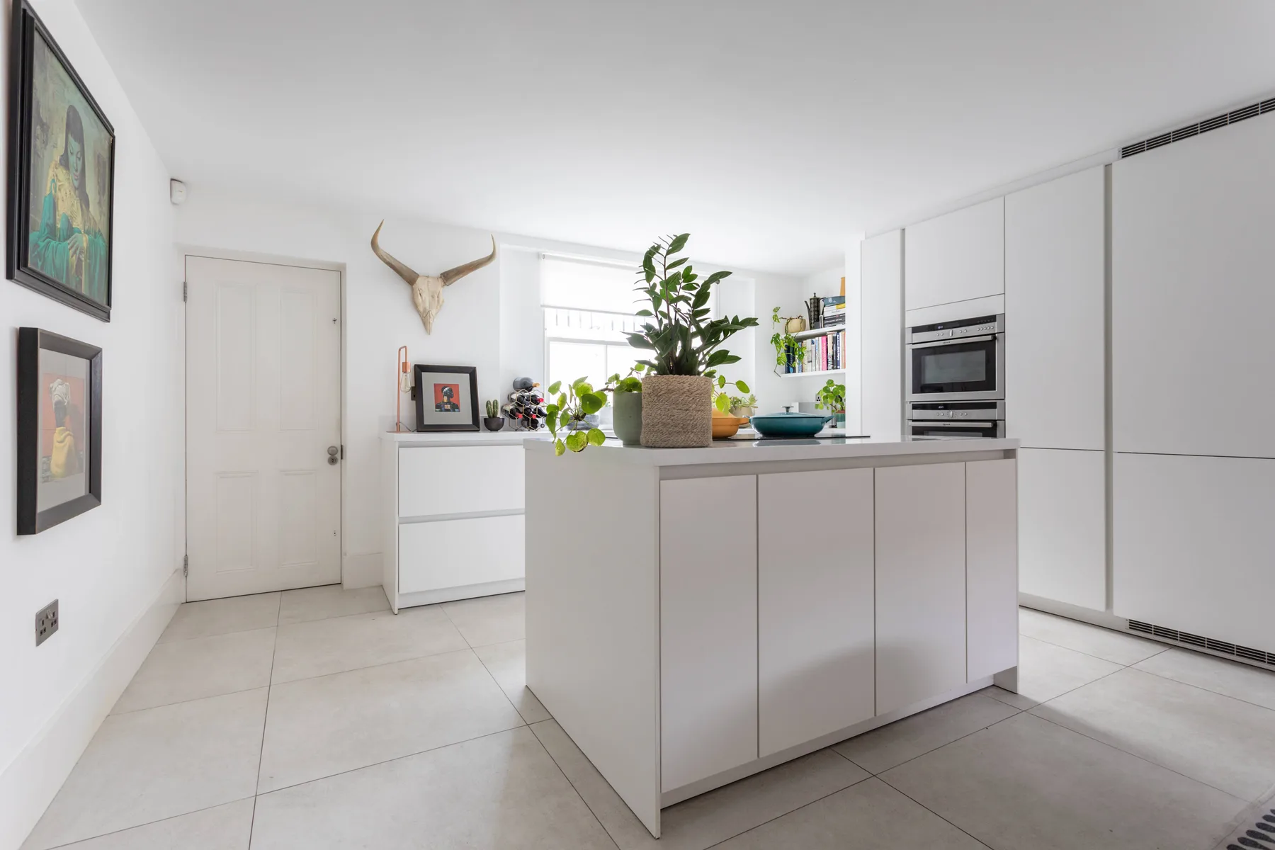 Una cocina moderna y luminosa con gabinetes blancos y una isla central.