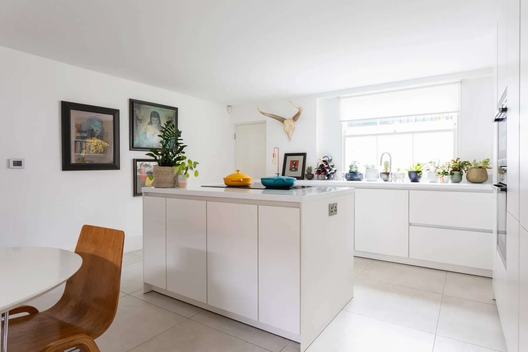 Una cocina luminosa con una isla central y una ventana amplia sobre la encimera.