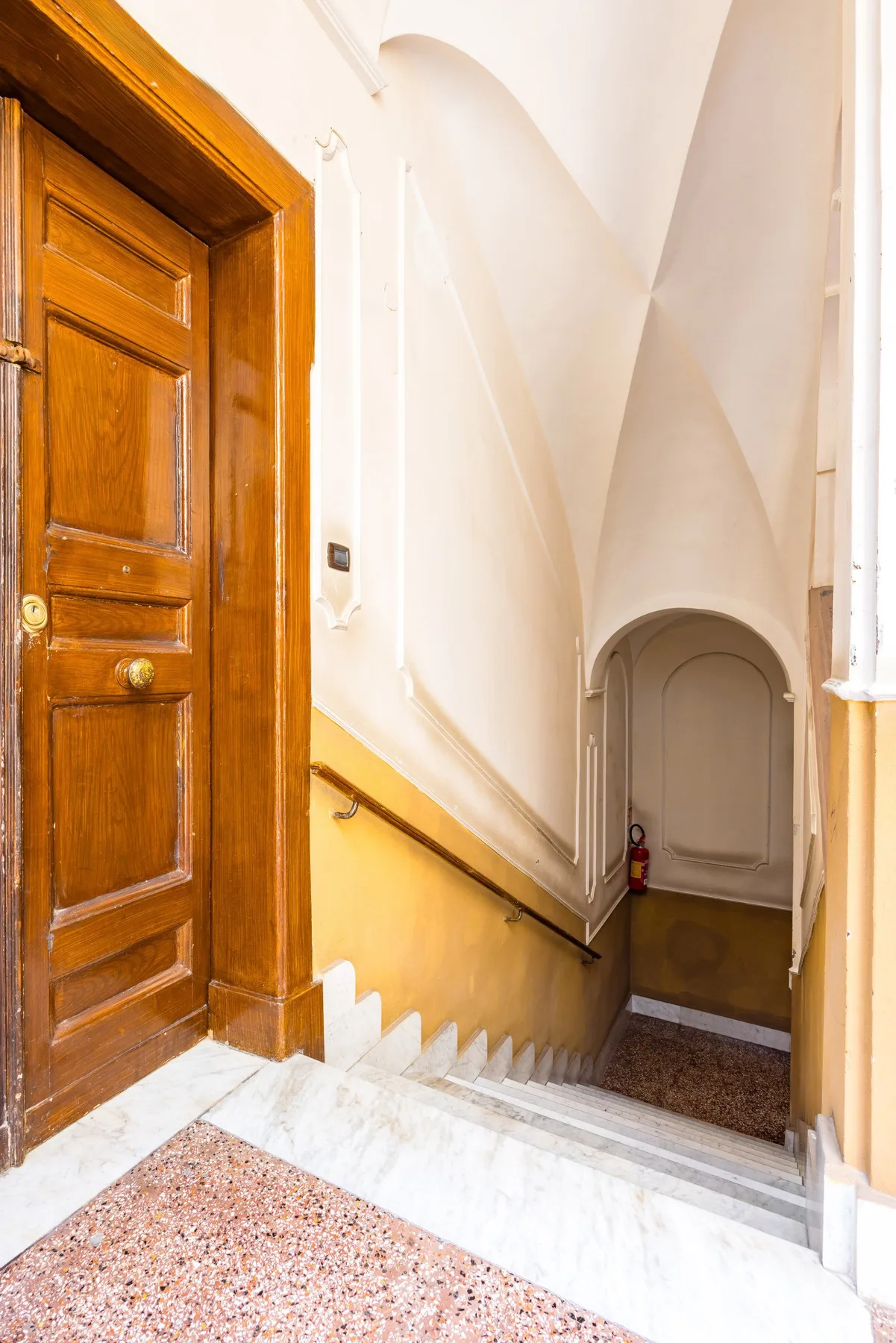 Una escalera con peldaños de piedra y una puerta de madera.