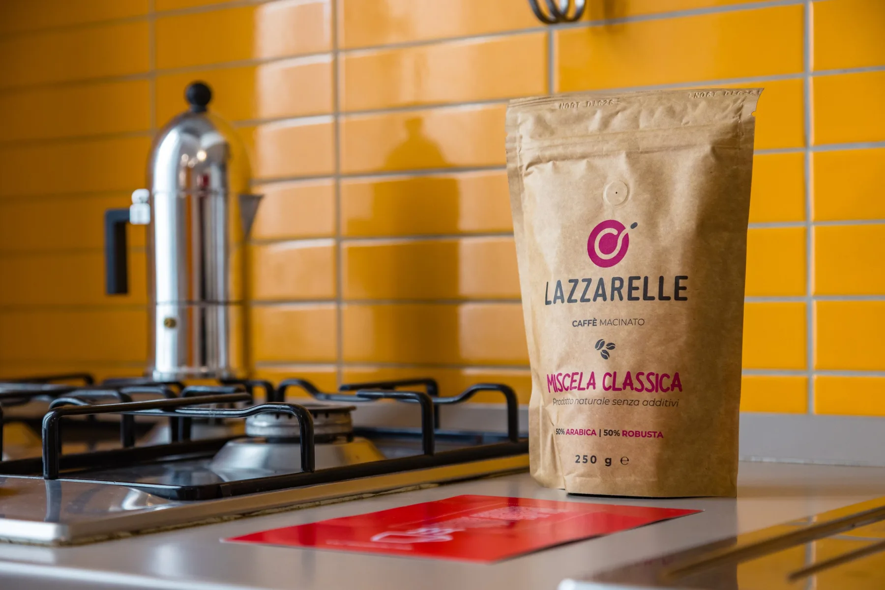 Una estufa de cocina y una bolsa de café están junto a un salpicadero de azulejos.