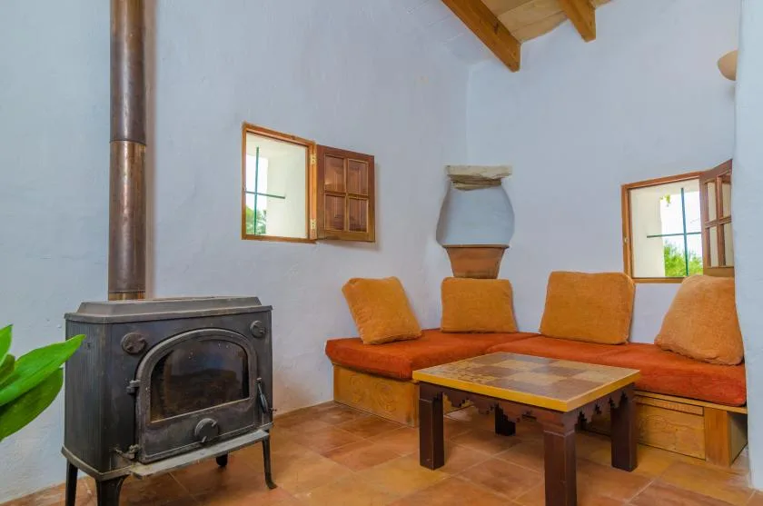 A living room with orange seating and a wood-burning stove.
