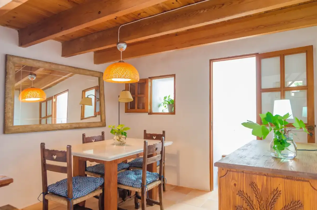 A dining area with a wooden table, chairs, and a large wall mirror.