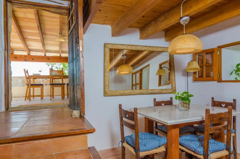 A dining area with a wooden table, chairs, and a large wall mirror.