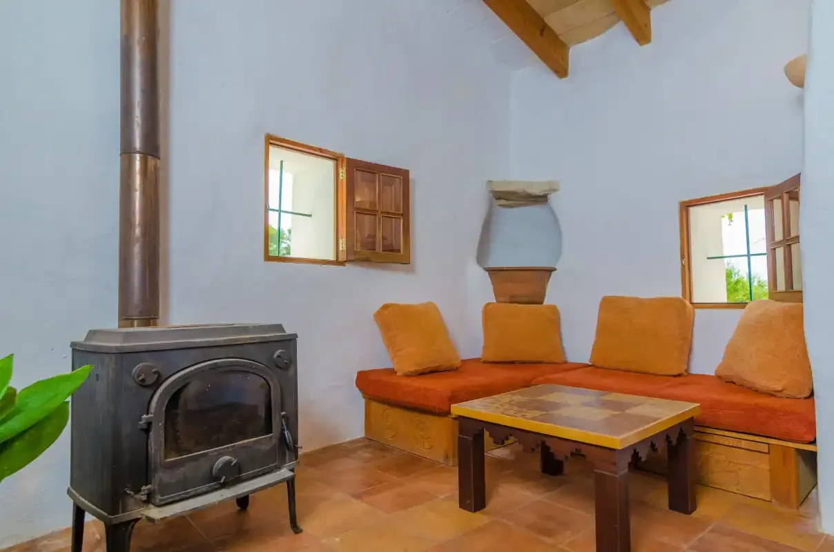 A living room with built-in seating and a wood-burning stove.
