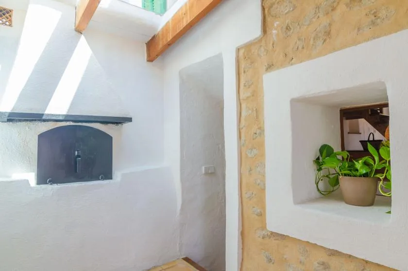 A bright white interior with a recessed fireplace and a potted plant in a wall niche.