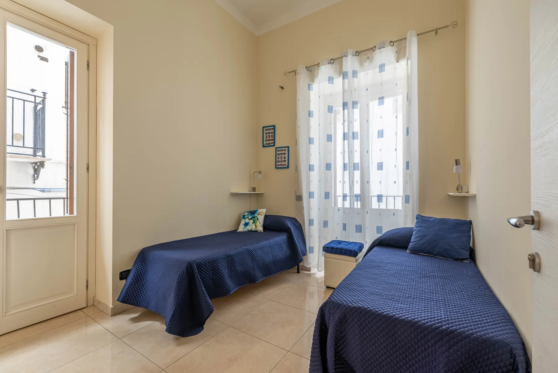 Un dormitorio con dos camas individuales cubiertas con colchas azul oscuro.