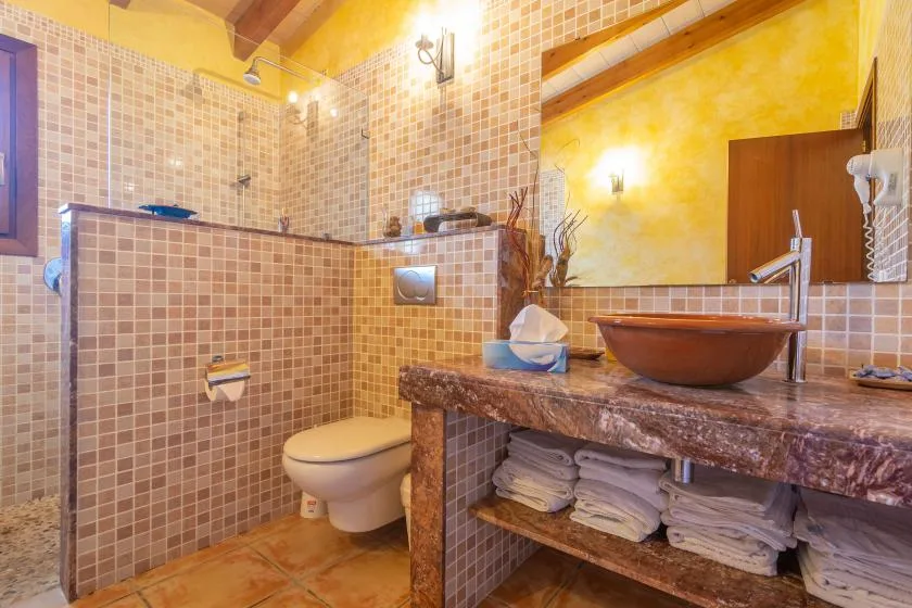 A tiled bathroom with a shower, toilet, and vanity.