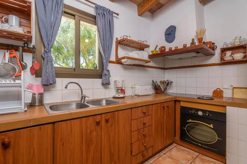 A tiled kitchen with wooden cabinets, a sink, and a built-in oven.