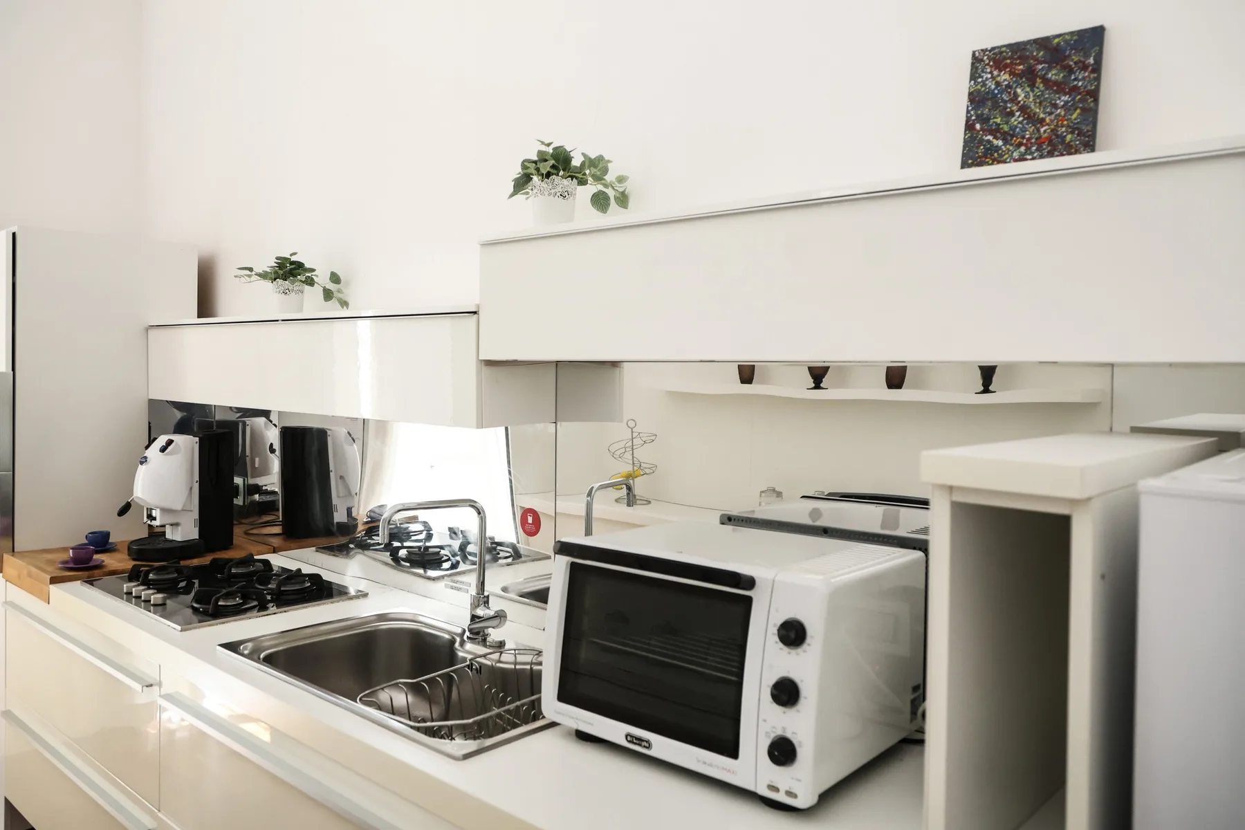 A bright kitchen with a countertop oven and sink.
