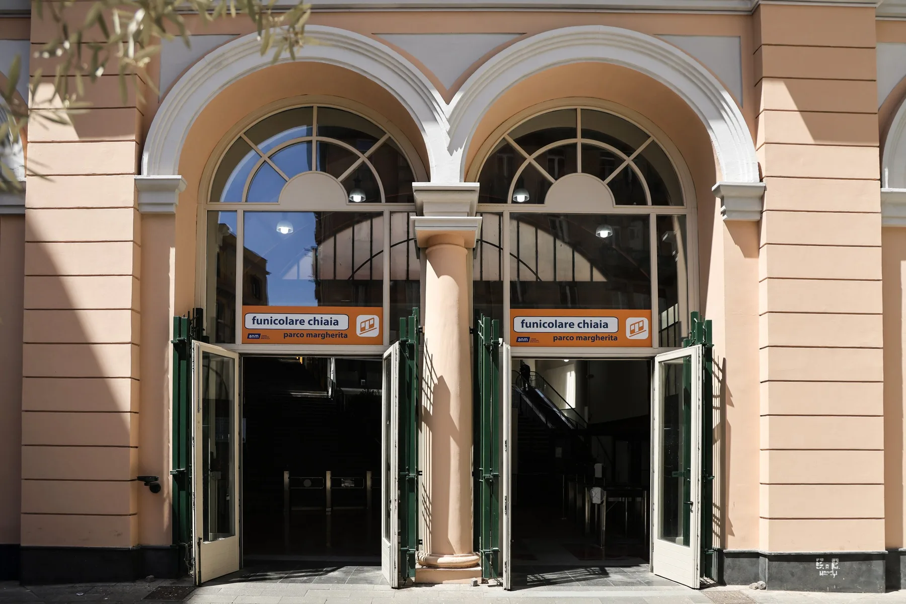 Building entrance with two arched doorways and signs above the doors.