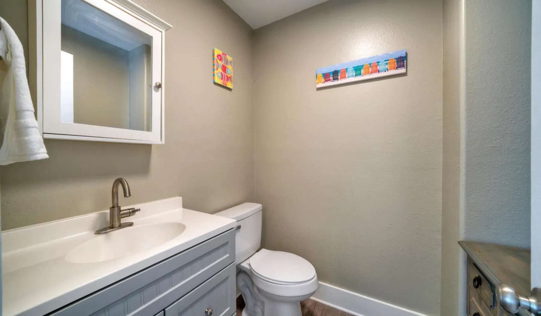 Un baño con lavabo, espejo e inodoro.