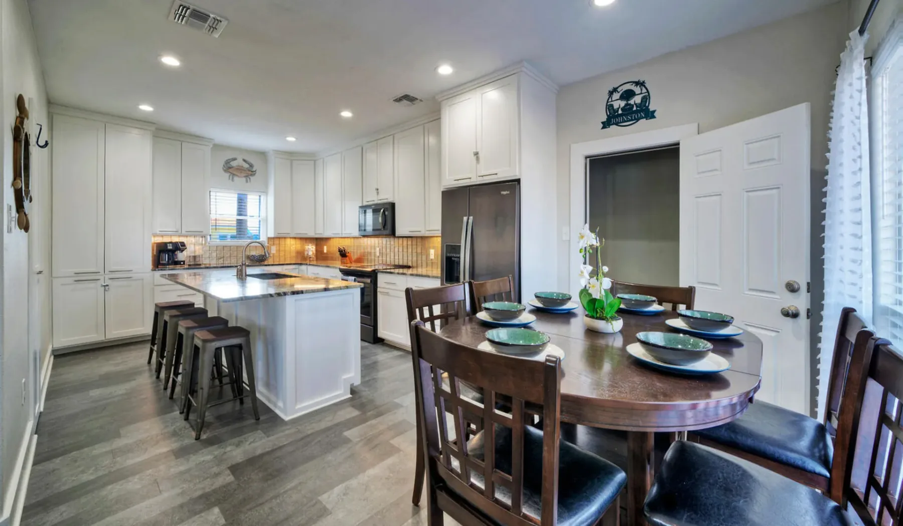 Una cocina luminosa con isla y una mesa de comedor de madera.