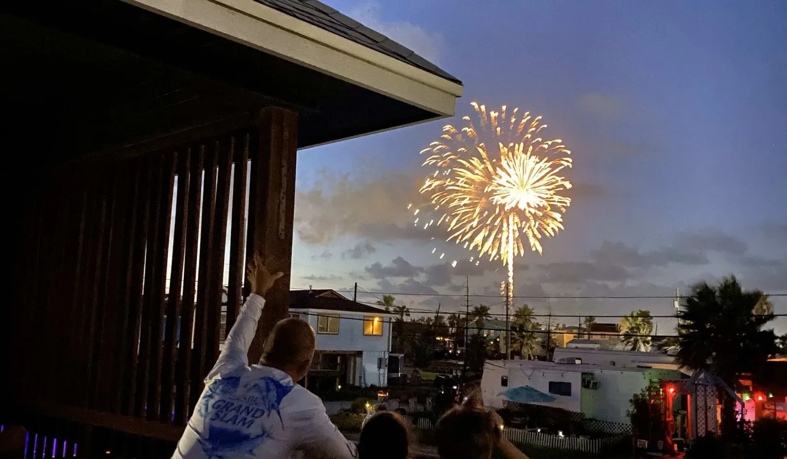Un espectáculo de fuegos artificiales ilumina el cielo nocturno sobre edificios cercanos.