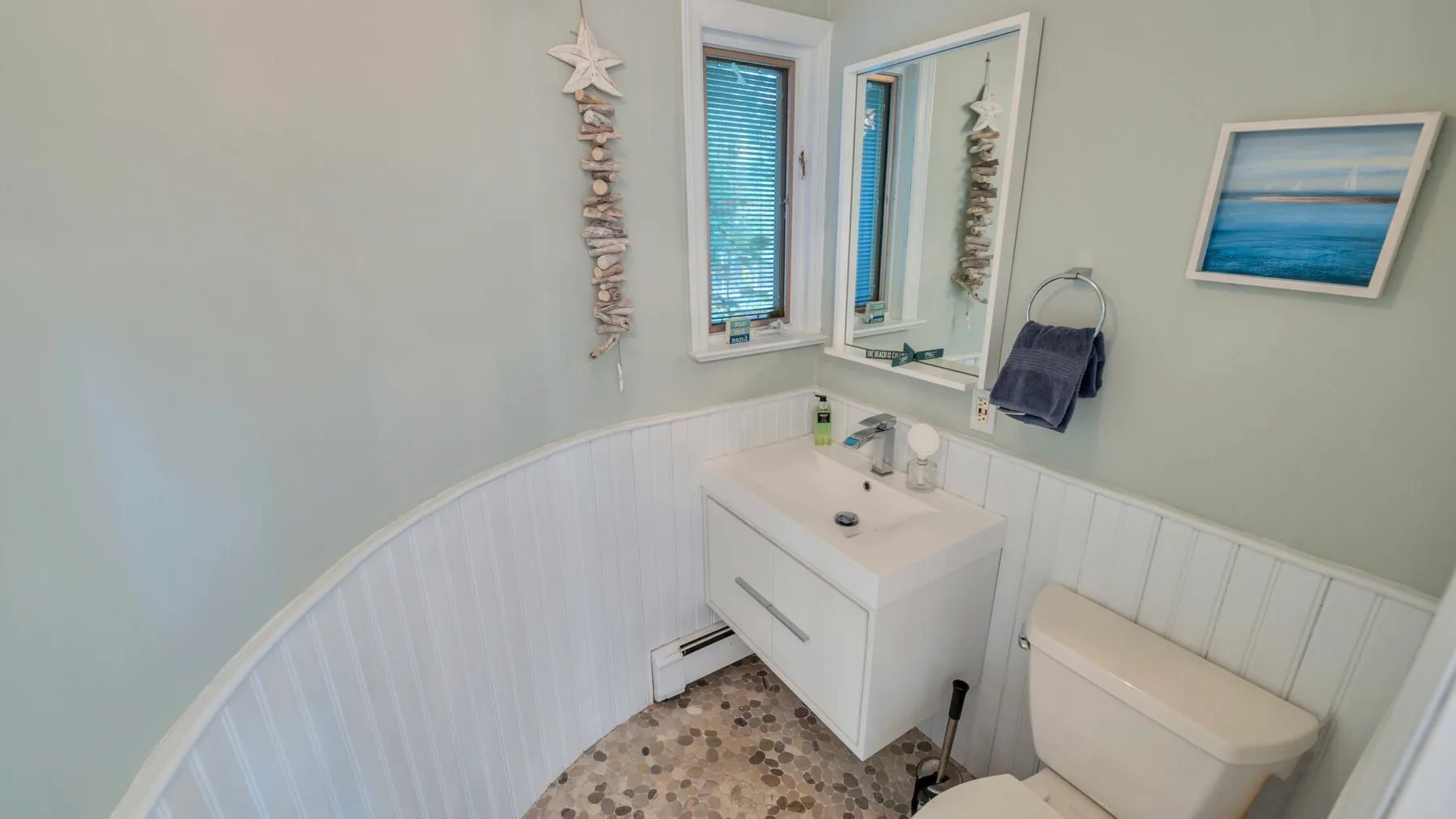 Un baño con lavabo, espejo e inodoro.