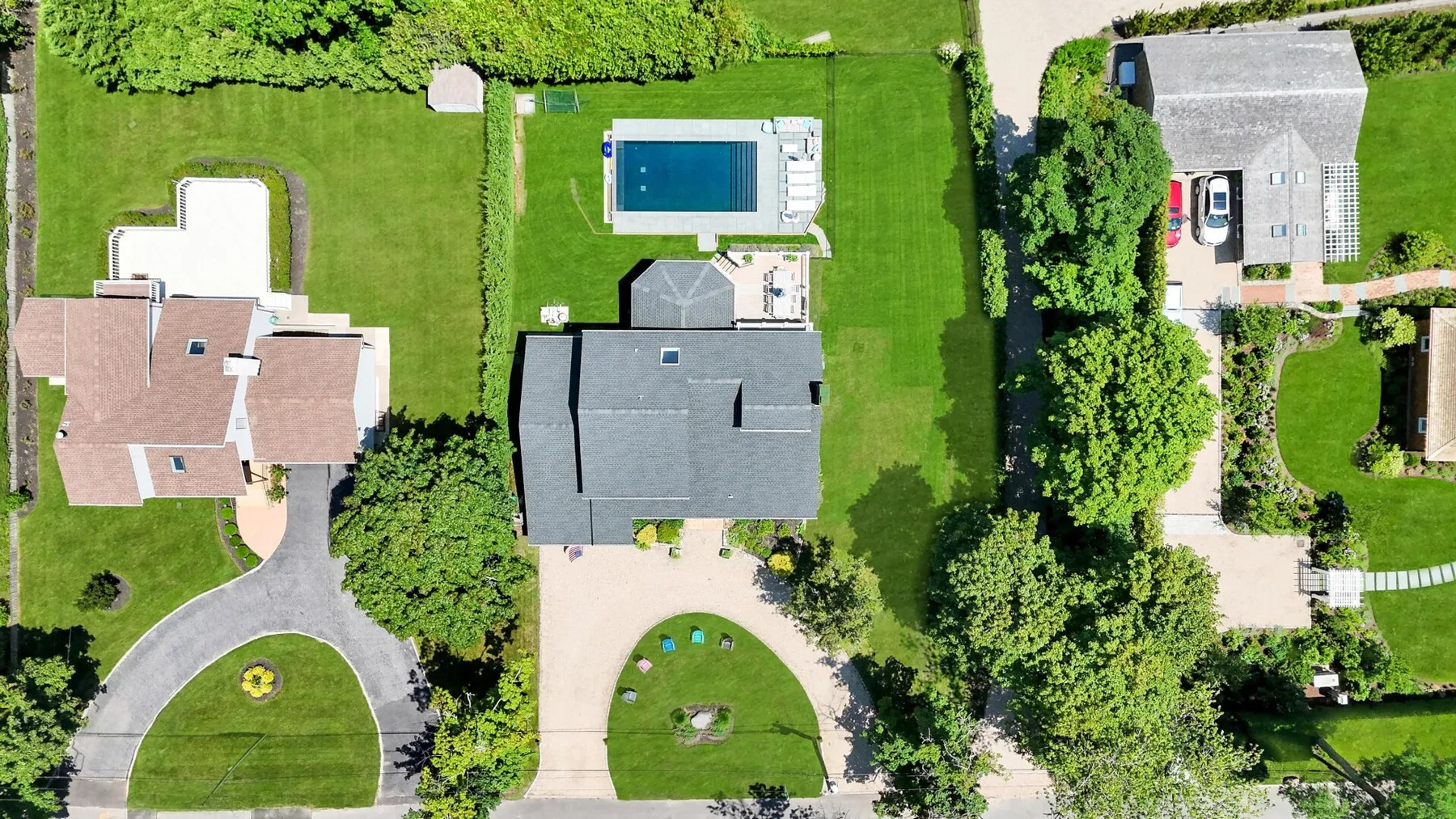 Una vista aérea muestra varios edificios, céspedes, árboles y una piscina.