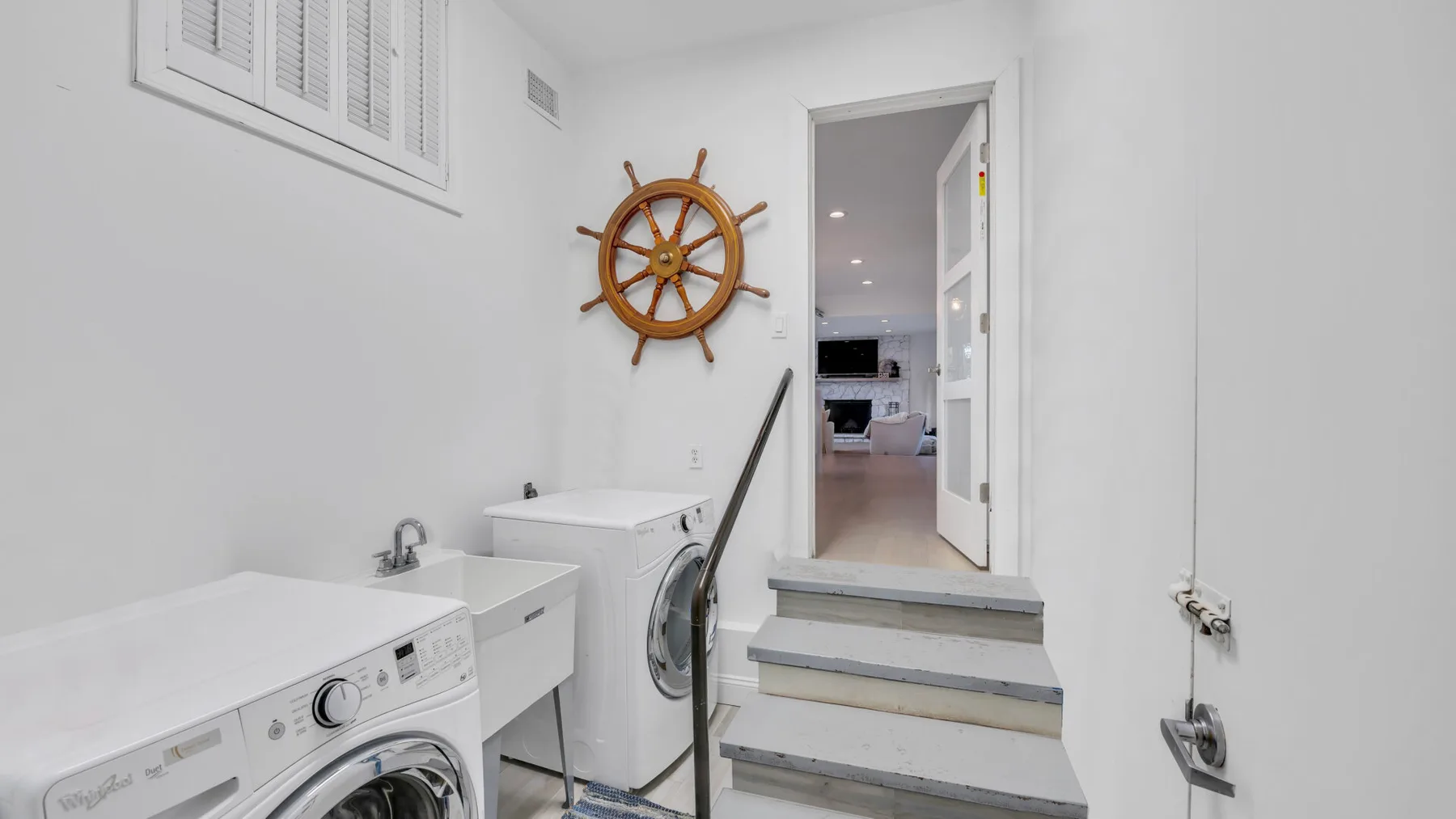 Una zona de lavandería con lavadoras y una puerta que da a otra habitación.
