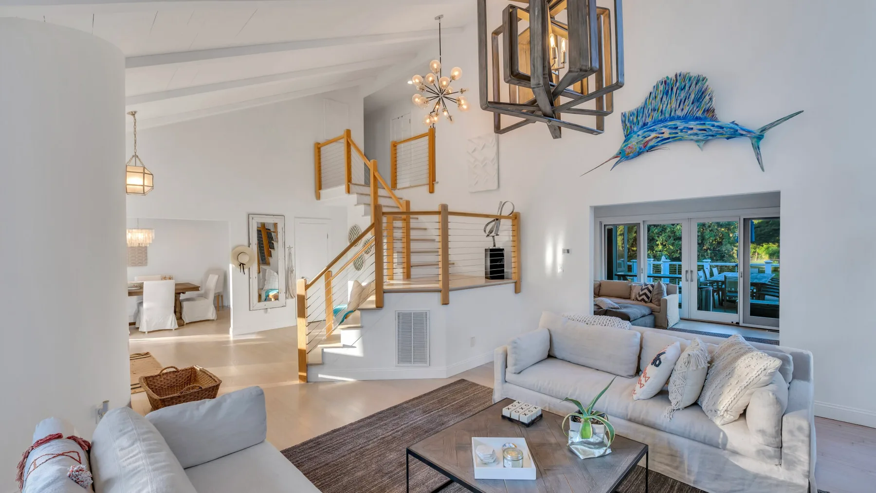 Una sala luminosa con asientos, una mesa de centro y una escalera.