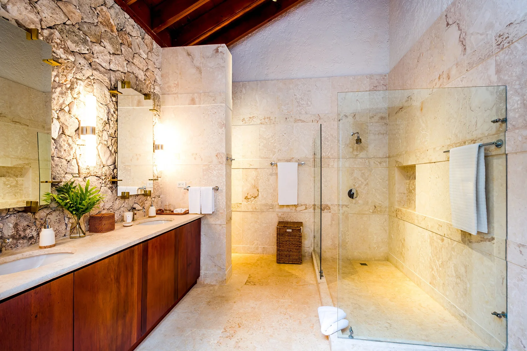 A spacious bathroom with a long vanity and a glass shower.