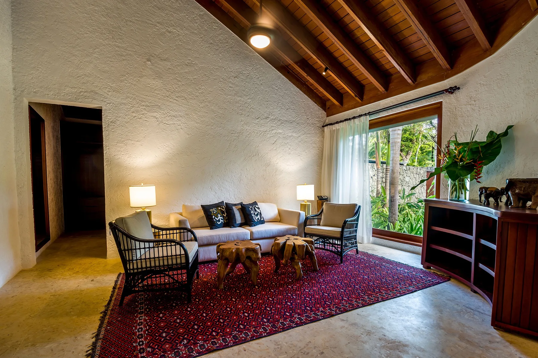 A living room with seating around a low table and a large window.