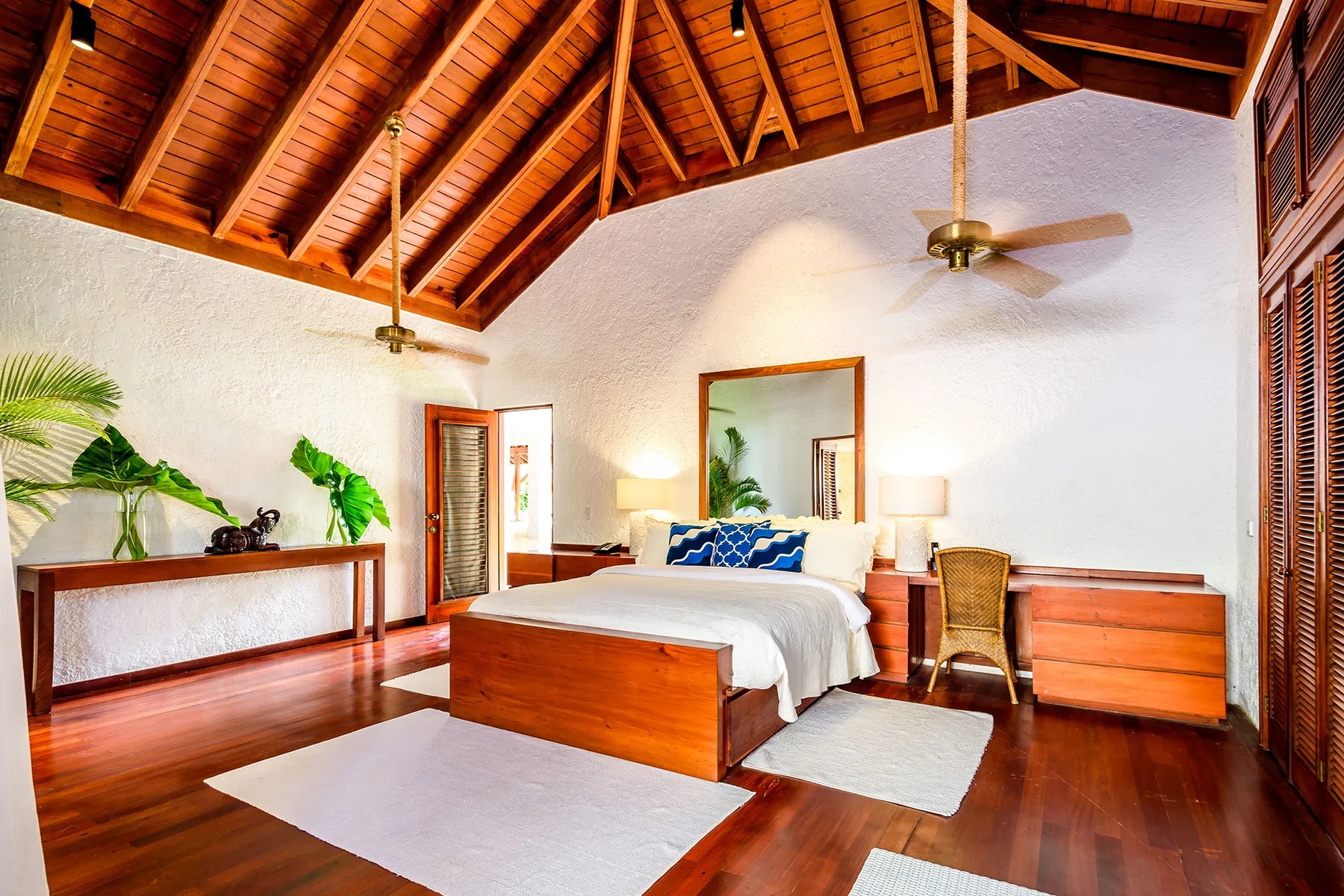 A bedroom with a wooden bed, bedside tables, and an exposed timber ceiling.