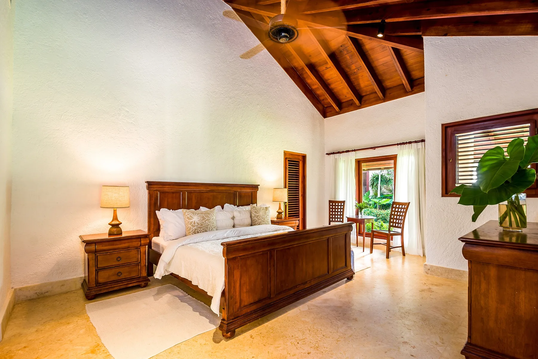 A bedroom with a wooden bed, bedside tables, and a ceiling fan.