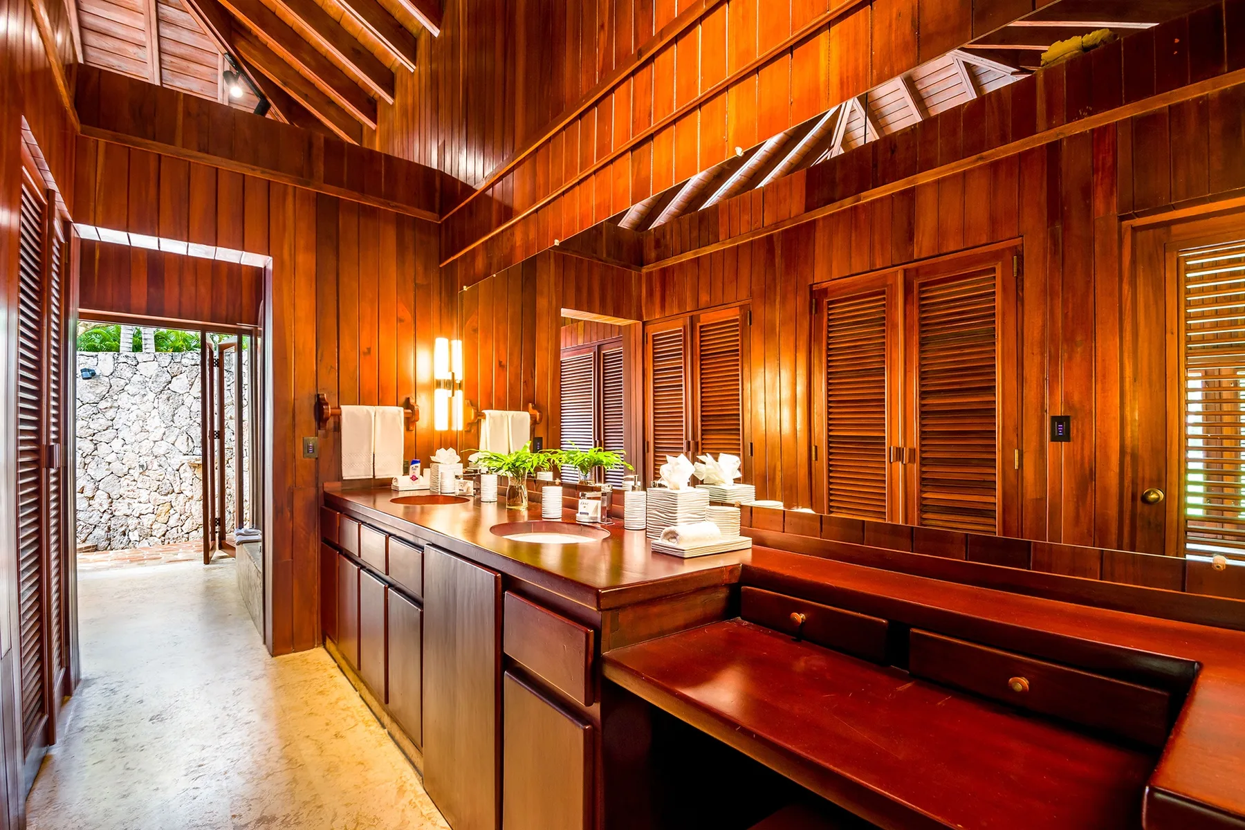 A wood-paneled bathroom with a long vanity and countertop sinks.