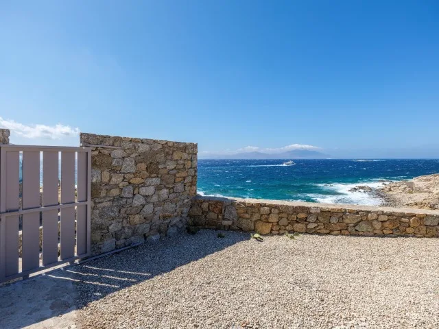 Una terraza de grava, delimitada por muros de piedra, da al mar.
