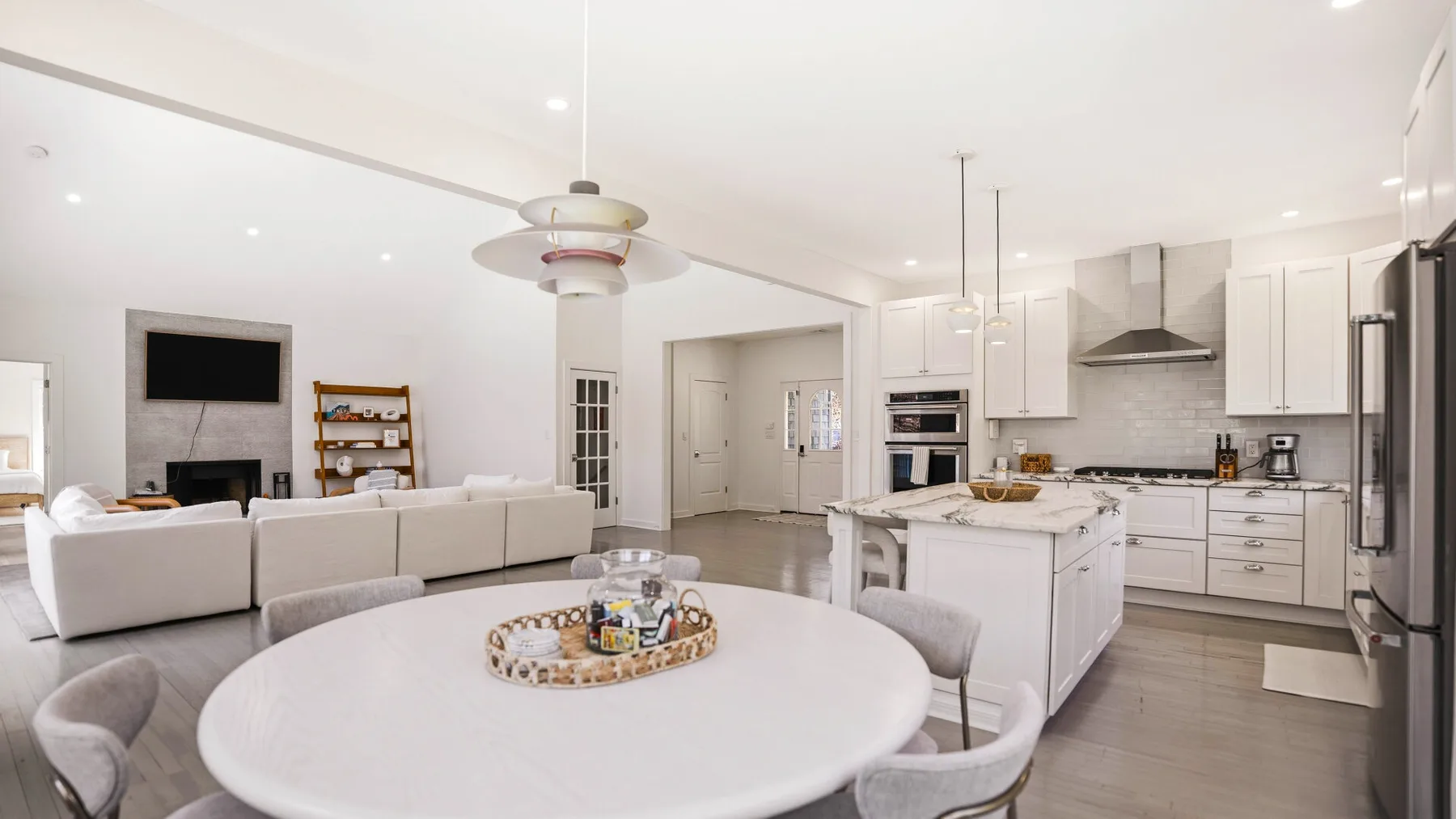 Una sala de estar y cocina de concepto abierto, con una mesa redonda en primer plano.