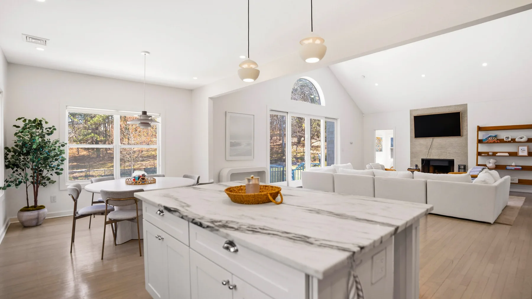 Una cocina luminosa y sala de estar de concepto abierto, con una isla grande y asientos.