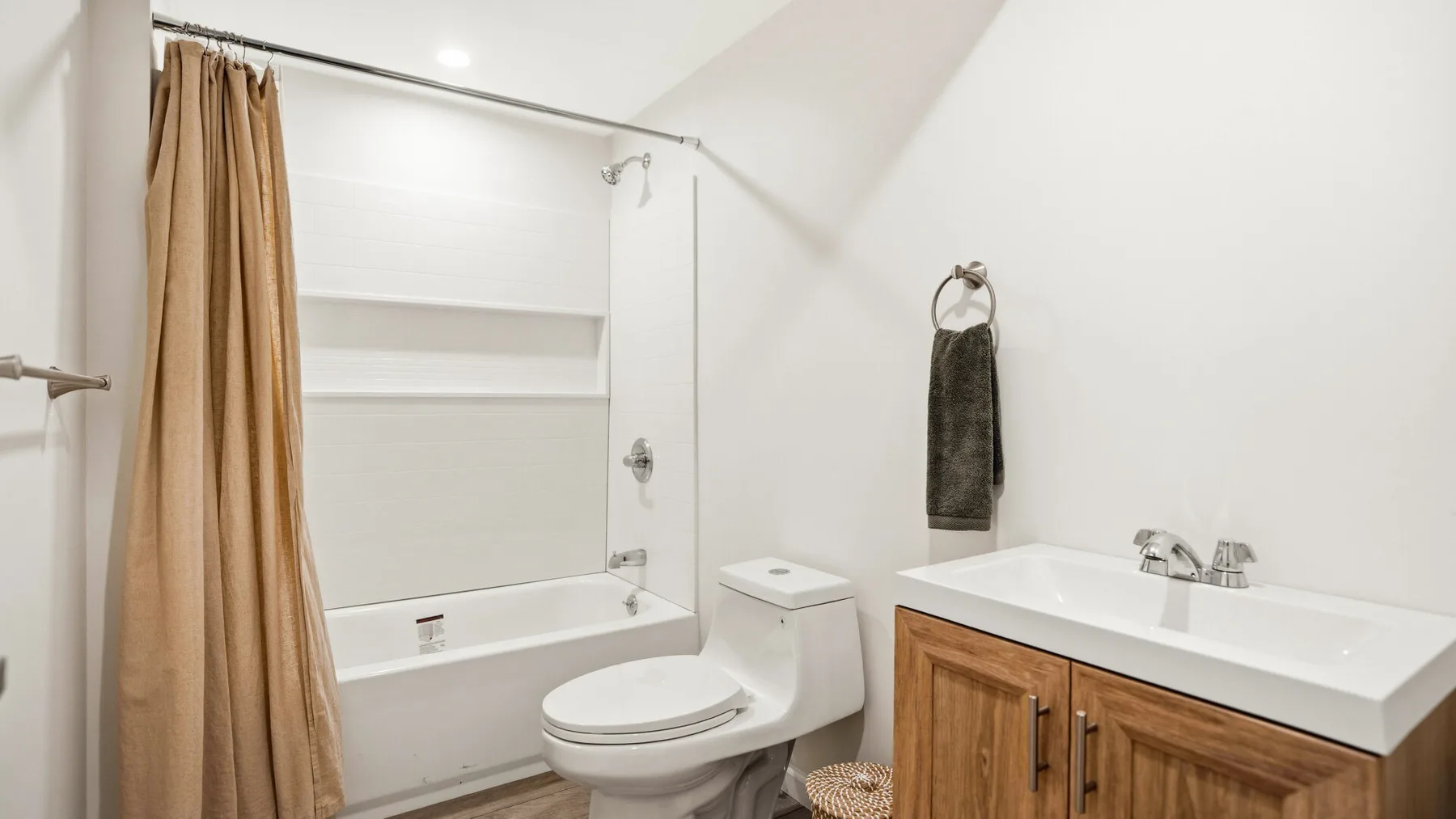 Un baño con bañera, inodoro y tocador con frentes de madera.