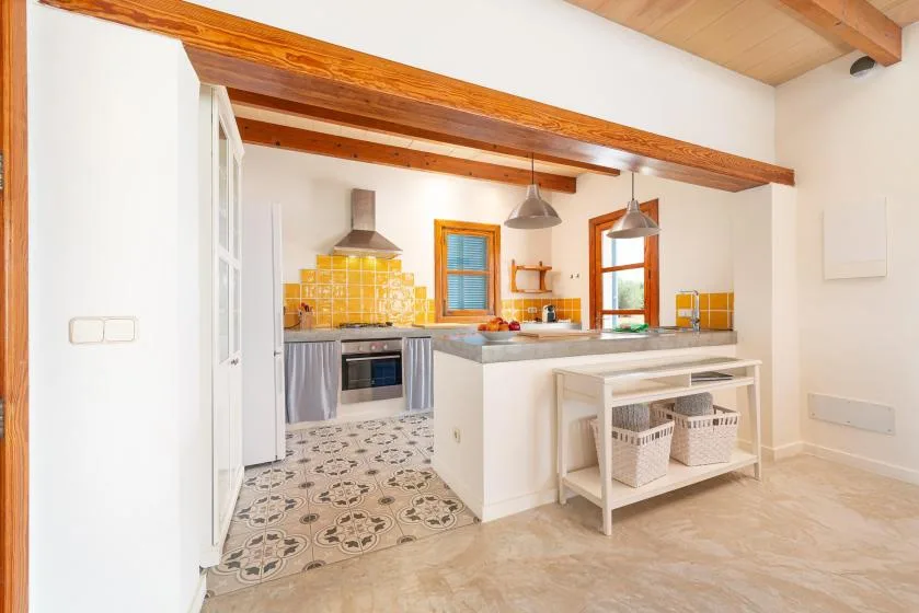 A bright kitchen with a central island and yellow tile backsplash.
